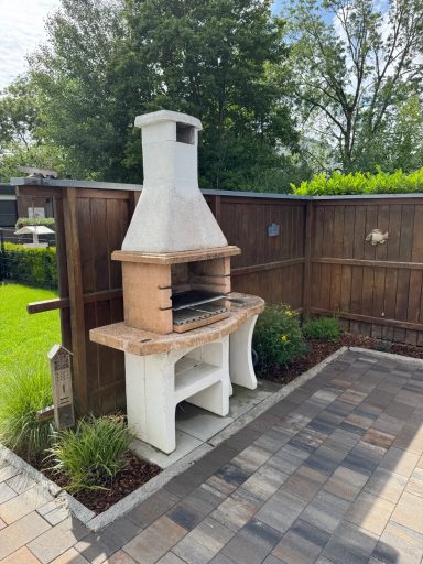 Ein Kamingrill auf einer gepflasteren Terasse